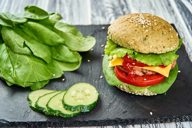 Hamburger con panino verde e verdure fresche