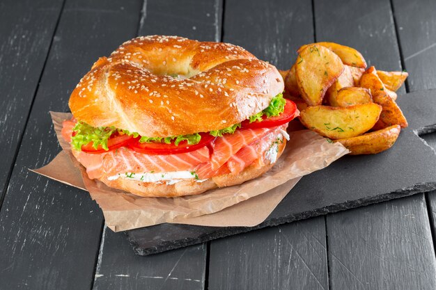 Hamburger con patatine fritte su un piatto di ardesia