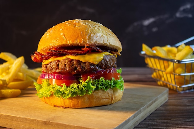 Hamburger con patatine fritte su una tavola di legno Messa a fuoco selettiva