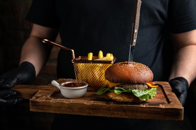 hamburger con pomodoro insalata cotoletta di formaggio nelle mani