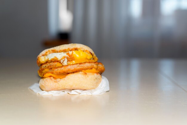 Hamburger con uova strapazzate e cotolette sul tavolo al chiuso, copia dello spazio.