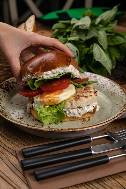 Hamburger con zuppa di cotoletta di pollo succo di pomodoro basilico pomodori in tavola