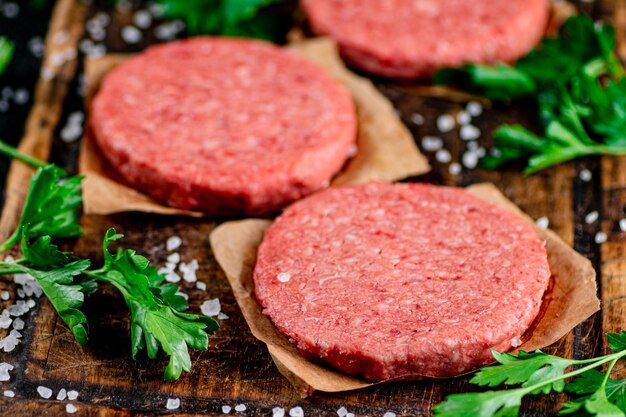 Hamburger crudo su tagliere con prezzemolo e sale