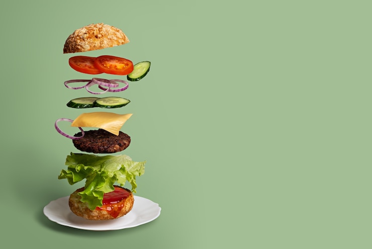 Foto hamburger delizioso con ingredienti volanti