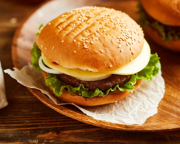 Hamburger delizioso fresco, servito su tavola di legno