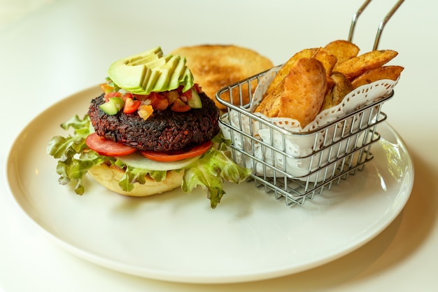 Hamburger di barbabietole con insalata in crosta di pane e patatine fritte.