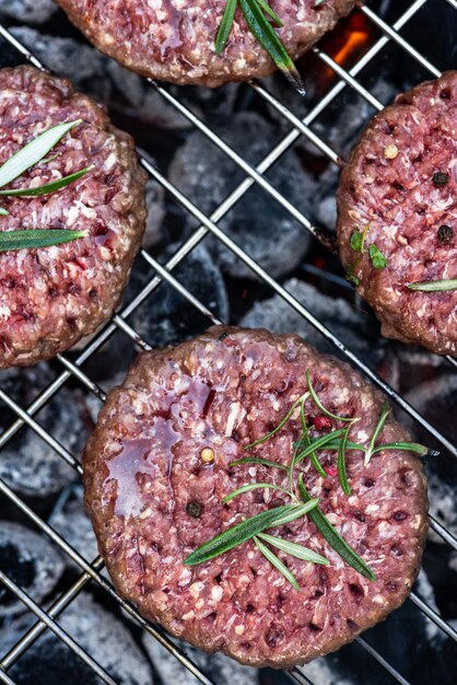 Hamburger di carne alla griglia su griglia a carbone BBQ vista ravvicinata