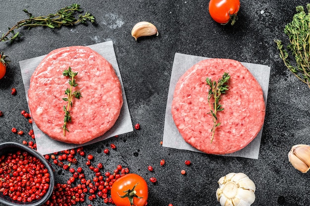 Hamburger di carne di manzo crudo su uno sfondo scuro