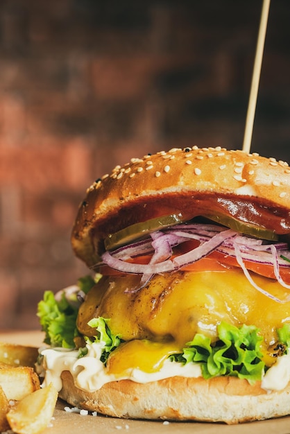 Hamburger di formaggio grande e saporito in panino di sezame con insalata