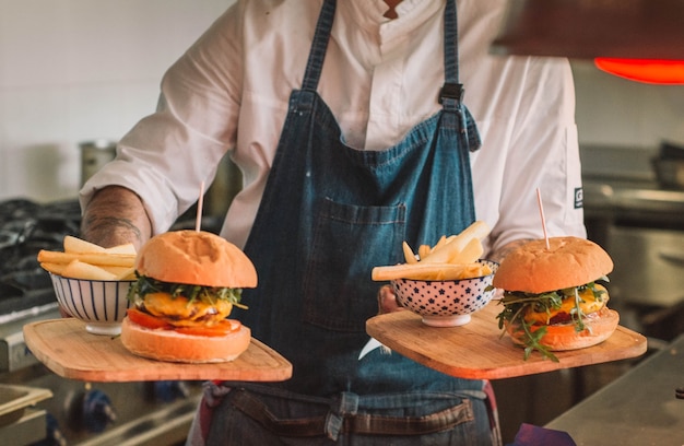 Hamburger di manzo al formaggio con patatine fritte su un tagliere