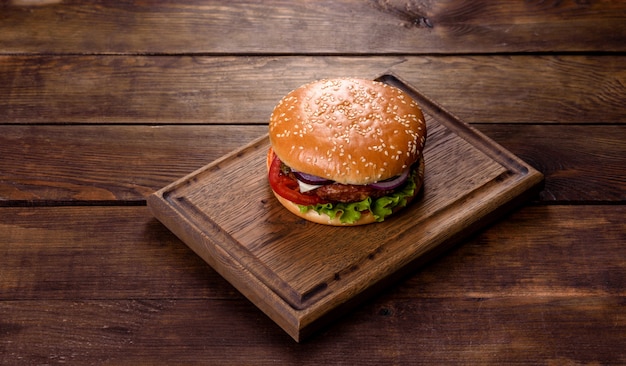 Hamburger di manzo artigianale e patatine fritte su sfondo nero