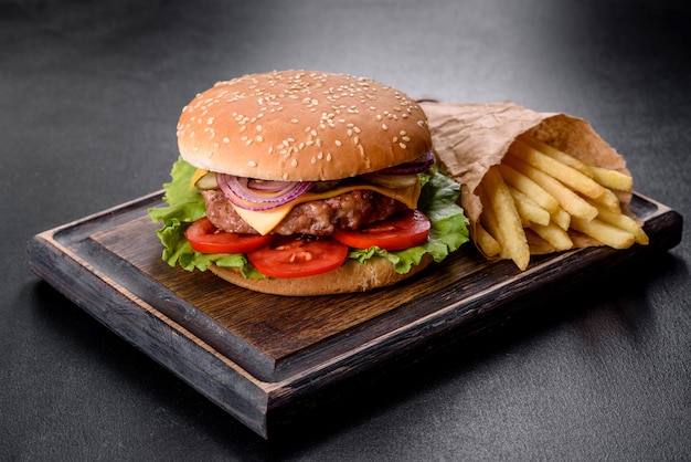 Hamburger di manzo artigianale e patatine fritte su sfondo nero