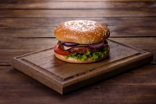 Hamburger di manzo artigianale e patatine fritte su sfondo nero