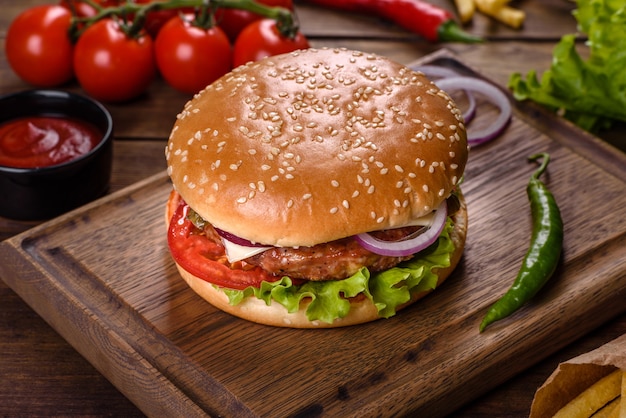 Hamburger di manzo artigianale e patatine fritte su sfondo nero