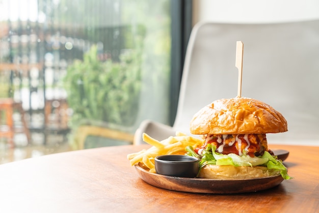 hamburger di manzo con formaggio e salsa sul piatto di legno