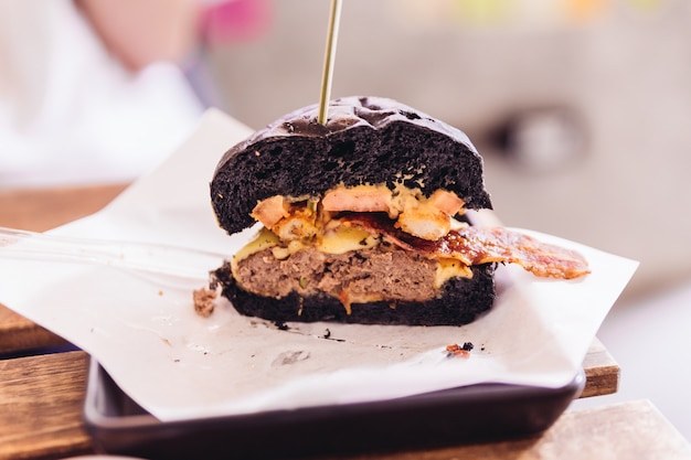 Hamburger di manzo con panino nero con formaggio