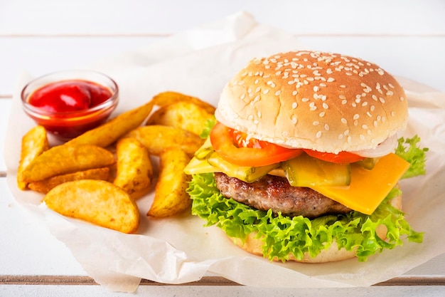 Hamburger di manzo con patatine fritte e ketchup su un tavolo di legno