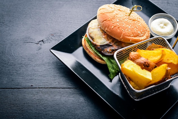 Hamburger di manzo Frittura di patate su fondo di legno Vista dall'alto Spazio libero per il testo