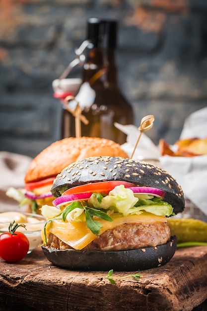 Hamburger di manzo nero classico alla griglia gustoso con lattuga e salsa di maionese su un tavolo in legno rustico, con spazio di copia