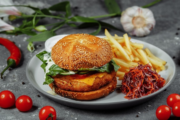 Hamburger di pollo con patatine fritte e insalata