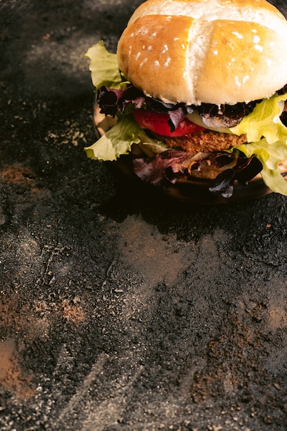 Hamburger di Seitan vegan su superficie di legno con verdure. Cibo vegano sano