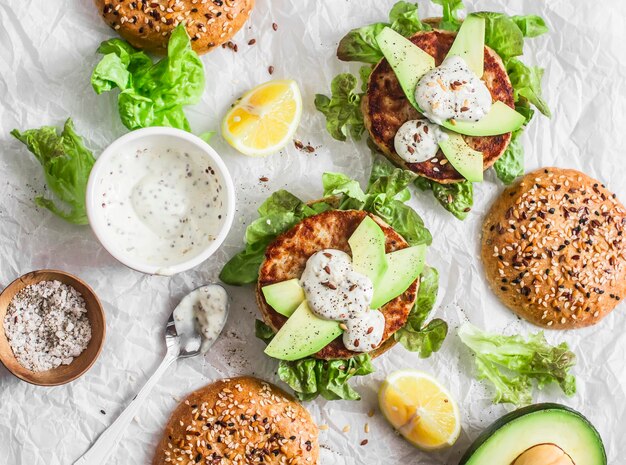 Hamburger di tonno su sfondo chiaro vista dall'alto Hamburger con avocado di tonno e salsa di senape