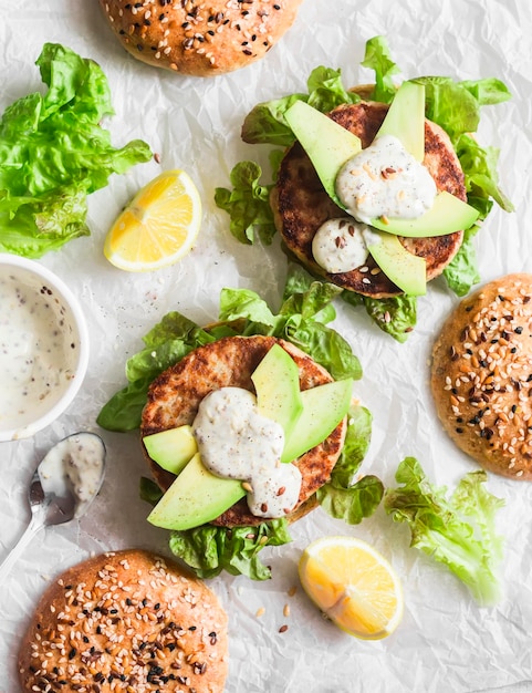 Hamburger di tonno su sfondo chiaro vista dall'alto Hamburger con avocado di tonno e salsa di senape