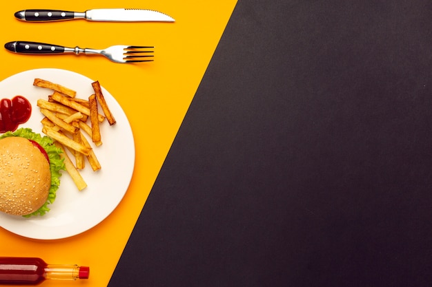 Hamburger di vista superiore con patatine fritte con lo spazio della copia