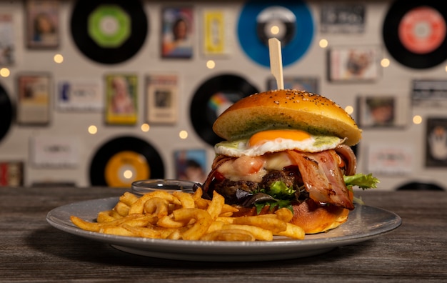 Hamburger di vitello fatto in casa con pancetta, formaggio e uovo fritto con patatine. immagine isolata