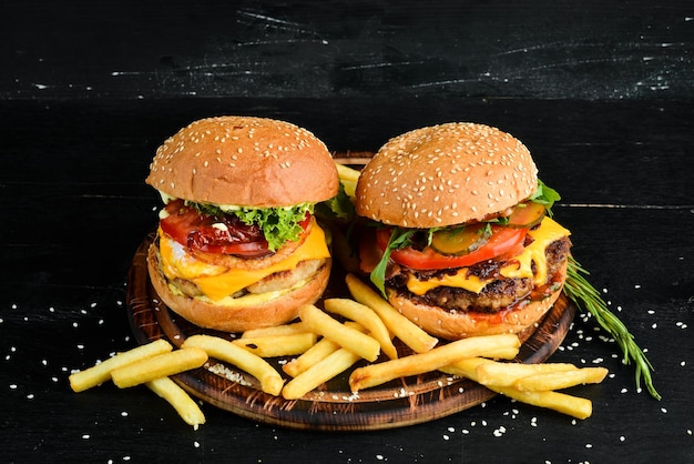 Hamburger di vitello, formaggio e verdure. Fast food. Su uno sfondo di legno. Vista dall'alto. Spazio libero per il tuo testo.