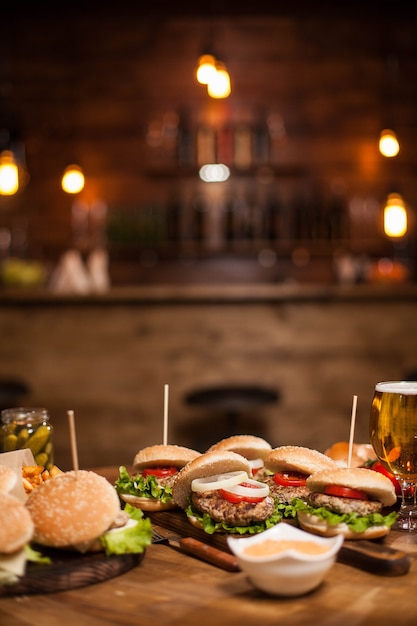 Hamburger e cheesburger deliziosi su un tavolo in un pub o ristorante vintage. Puoi vedere l'interno sfocato sullo sfondo