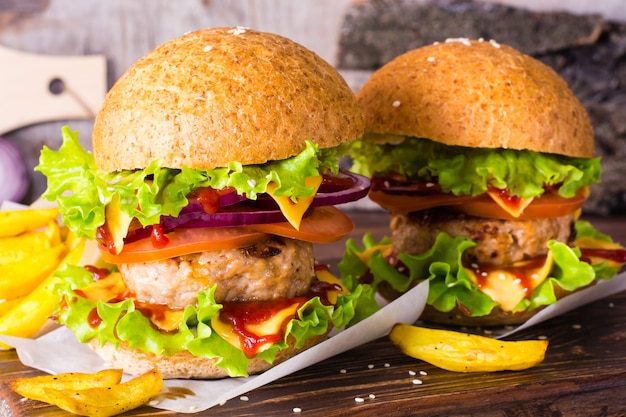 Hamburger e patate fritte su una tavola di legno