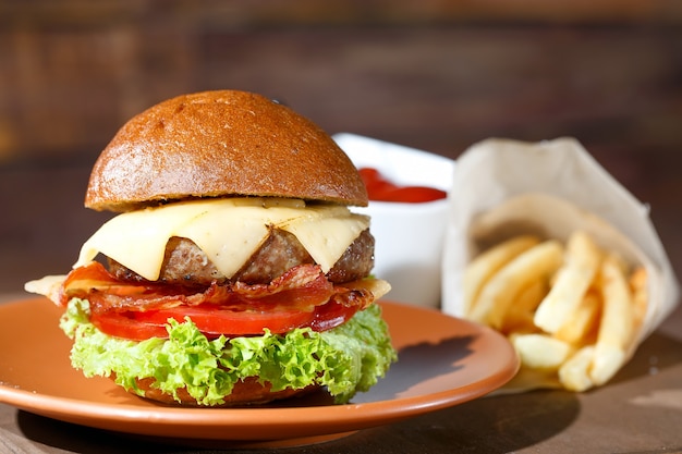 Hamburger e patate fritte sulla tavola di legno.