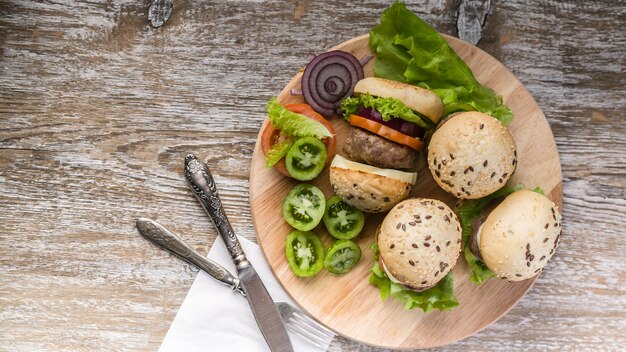 Hamburger fatti in casa alla griglia con carne di manzo, pomodori, formaggio, cipolle dolci e insalata verde.