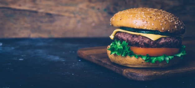 Hamburger fatto in casa (cheeseburger) con manzo su un fondo di legno. Burger classico fatto in casa.