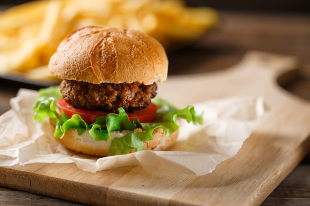 Hamburger fatto in casa con patatine fritte sul tavolo di legno