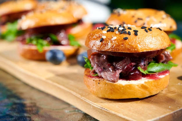 Hamburger freschi fatti in casa con pancetta, basilico, pomodori e frutti di bosco