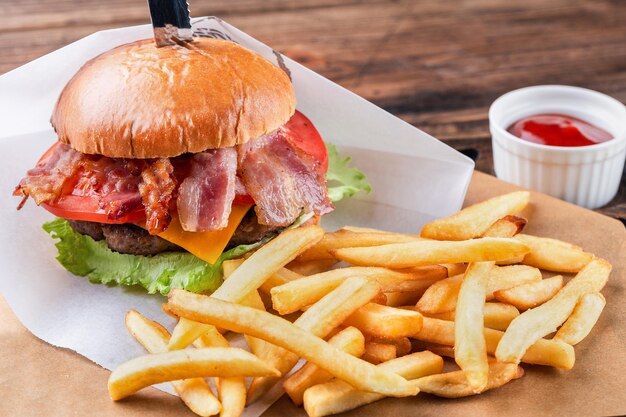 Hamburger fresco con patatine fritte su un tavolo di legno