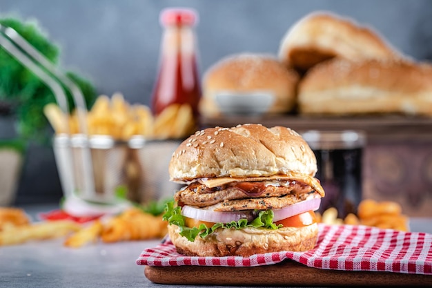 Hamburger gustoso con patatine fritte su sfondo scuro