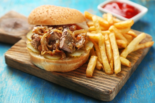 Hamburger gustoso e patatine fritte su sfondo tavolo in legno Concetto di cibo malsano