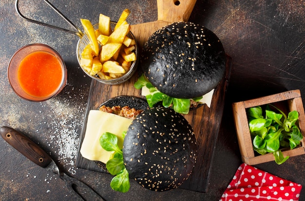 hamburger nero con patate gratis su tavola di legno
