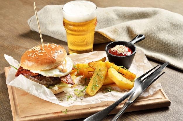 Hamburger, patate messicane e ketchup su tavola di legno