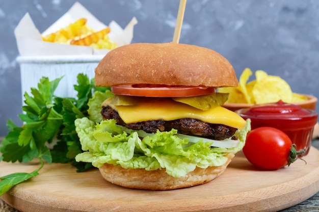 Hamburger, patatine fritte, patatine fritte, salsa su un fondo di legno. Cibo di strada. Set di prodotti fast food.