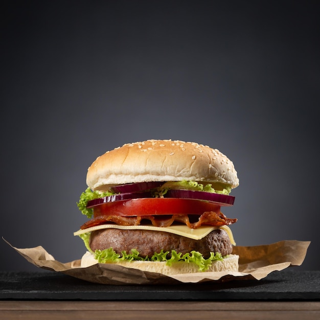 Hamburger su base di legno su sfondo scuro