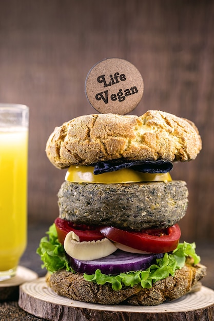 Hamburger vegano, con hamburger a base di soia. Cartello in legno scritto in inglese: Vegan Life