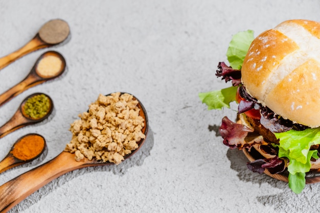 Hamburger vegano di soia su superficie di legno con verdure. Cibo vegano sano.