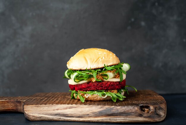 hamburger vegetariano con barbabietole, ceci, pera, rucola, cetriolo su un tagliere