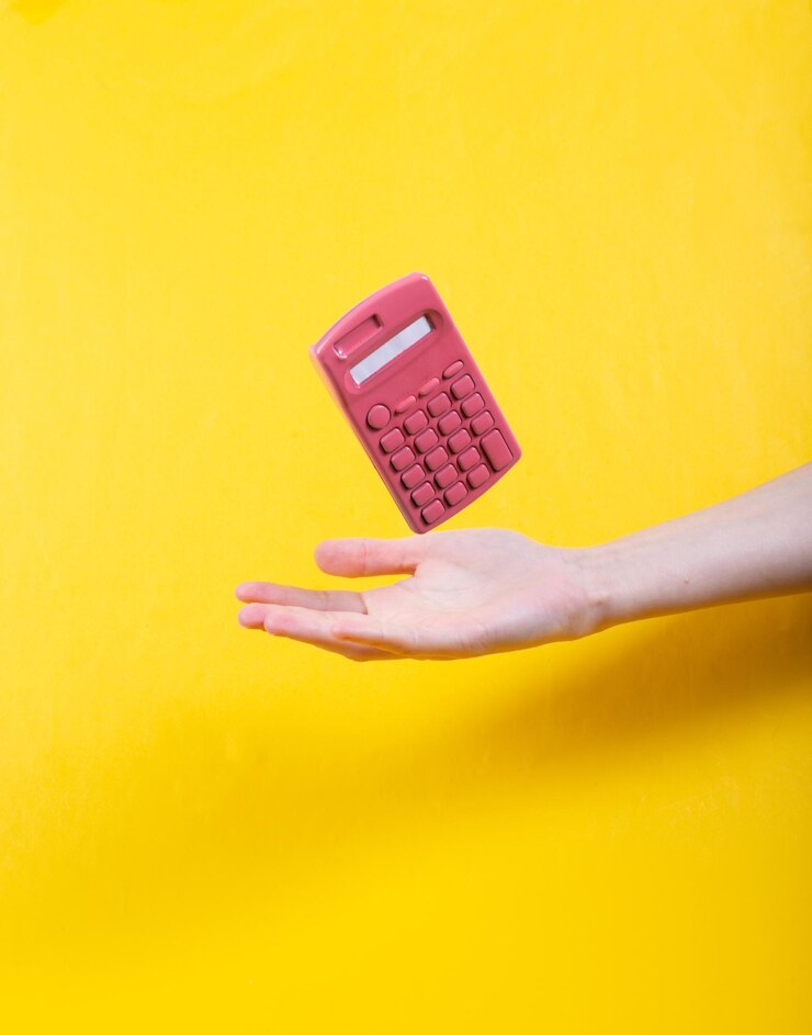 Hand and Levitating pink calculator on yellow background Minimalistic still life Concept art