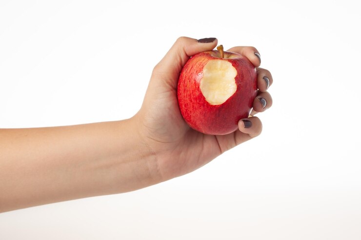 Hand holding bitten red apple isolated on white background