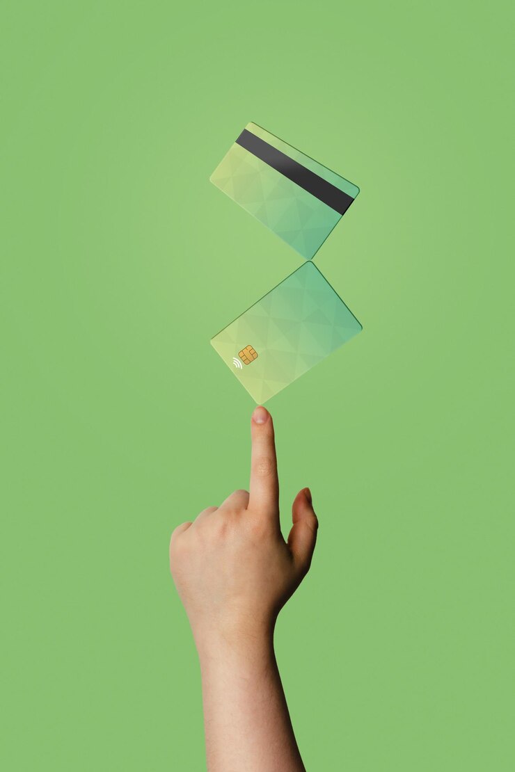 Photo hand with floating credit cards with green background and copy space